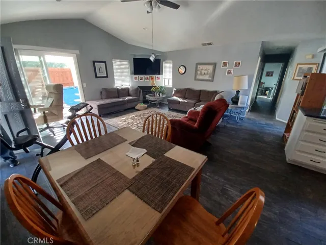 View from kitchen island into Great Room with vaulted ceilings, recessed lighting and ceiling fan. Front door to the left then sliding door to sideyard. Beautiful tile froors in great room, kitchen, hallway and baths.