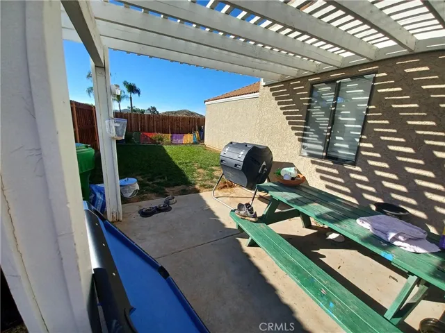 Patio w/ lattice cover. Large lawn area.
