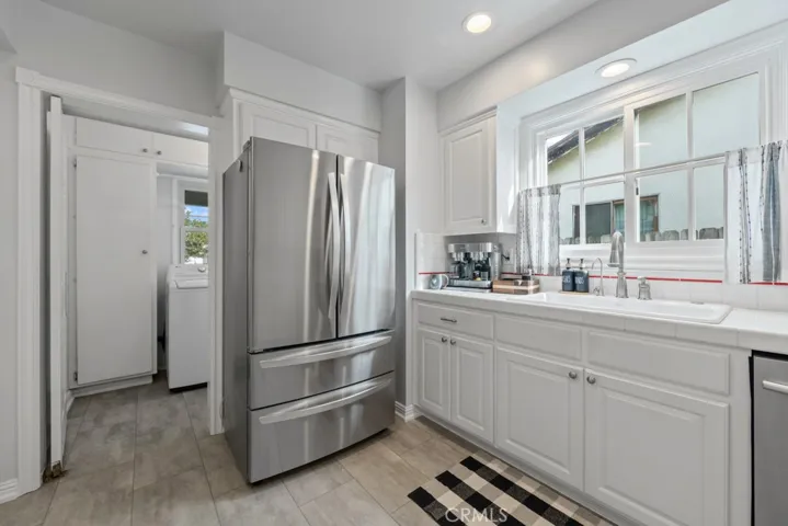 Kitchen shows open door to separate laundry room