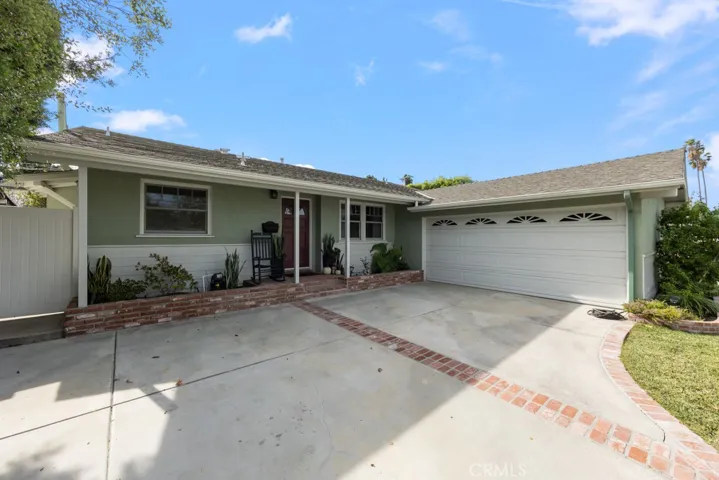 Front view shows brick inlay in driveway tying into porch and flowerbed