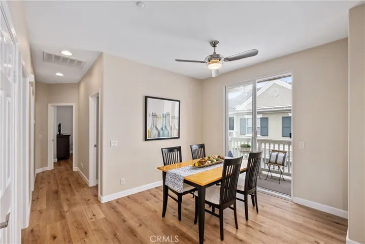The dining room with a ceiling fan and access to the second balcony.