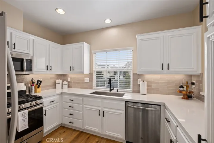 Remodeled kitchen with designer paint, white cabinets, stainless steel appliances, quartz countertops and a pantry.