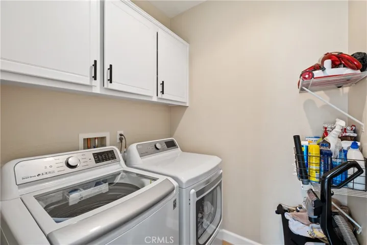 Laundry room with cabinets and shelves for storage.
