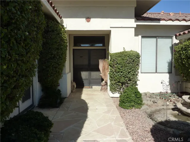 Level entry and level access to the front door. The court yard fountain is on the right and the den off the master suite is on the left side.