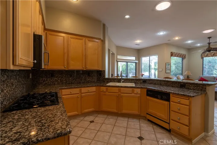 The kitchen has granite counter tops and a breakfast bar that is open to the dining nook and family room