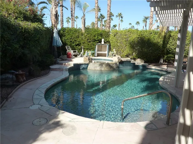Beautiful free form pool with a built in spa on the left side of the home.