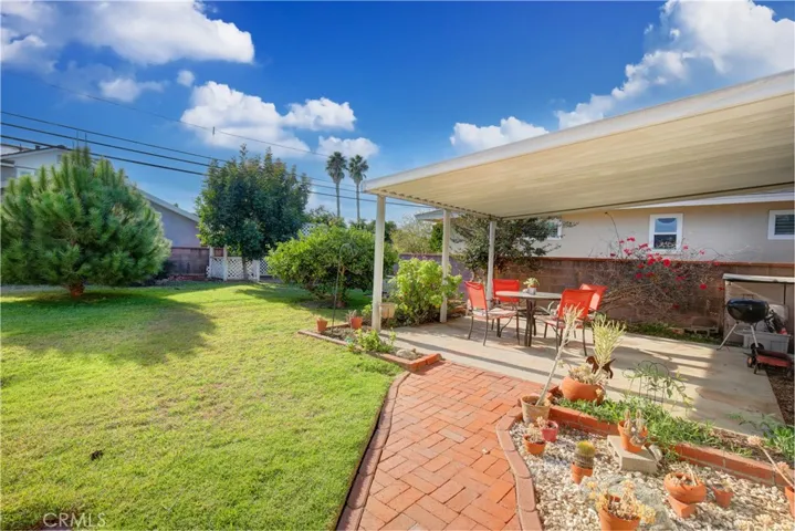 Private backyard with mature fruit trees and covered patio.
