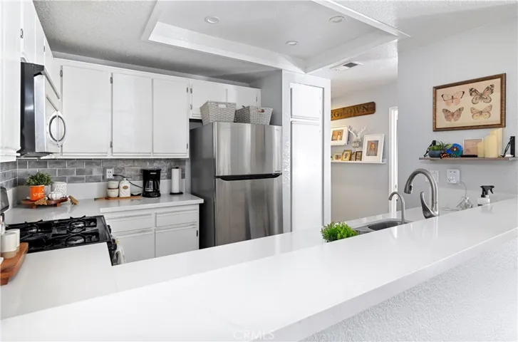 Kitchen with beautiufl white quartz countertops with a trendy gray subway backsplash.