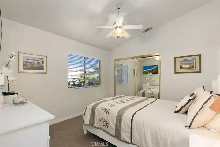 Secondary bedroom boasts a view of the large, tropical front yard