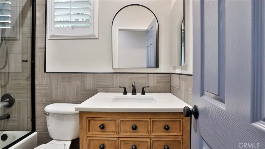 The downstairs bathroom has new floor and wall tile with Schleuter aluminum trim, a new vanity, mirror, medicine cabinet, tub and shower enclosure and fixtures.