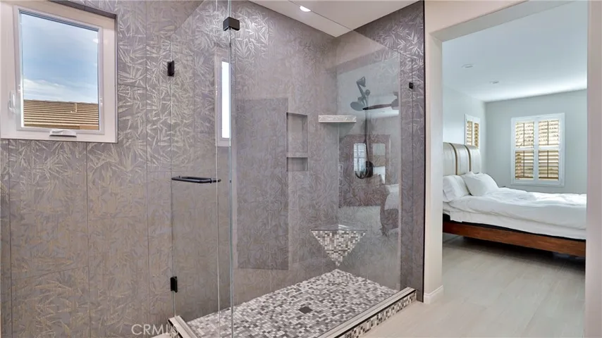 A shower built for two?!  Beautiful textured tile adorns both the shower and southern wall.  A must see! The primary bath has redesigned from the original builder's floorplan.