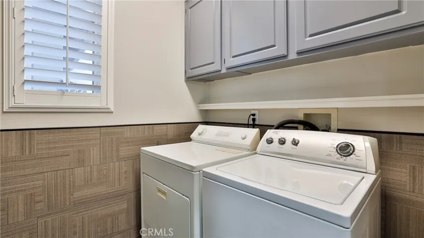 The laundry room is adjacent to the kitchen with generous storage (may double as a pantry) and remodeled.
