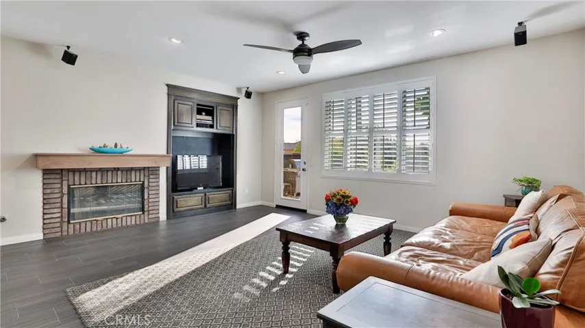 The fireplace is both gas and wood burning with traditional chimney.  The entertainment center is built-in.  Another door leads to the backyard/pool area.