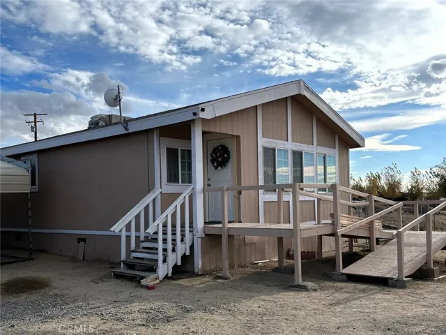Front of home with stairway and ramp.