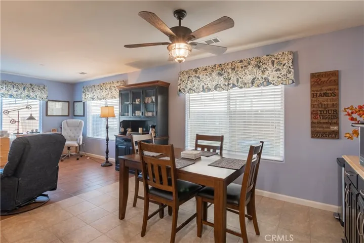 dining room with ceiling fan and faux wood blinds