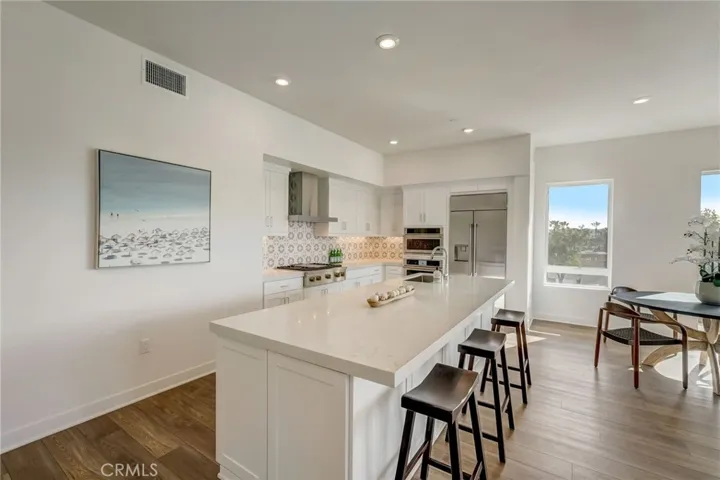 Revel in the open concept kitchen with upgraded designer tile backsplash and this sprawling quartz countertop island seamlessly connecting to the expansive great room.