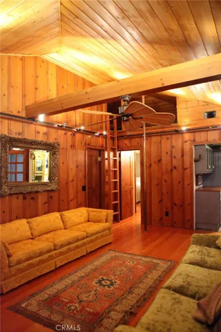 Living room located off the entry level.  See the fireman's pole and stairs leading to a "play area" (or extra storage)  But darling.  Knotty Pine preserved from original residence.  Maple floors.  3 bedrooms off of this room and one bath
