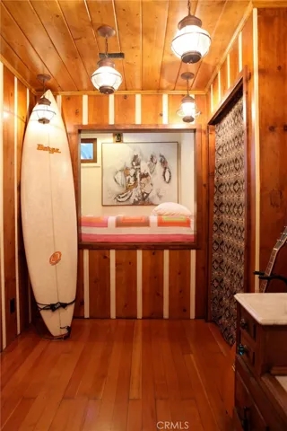 One of the three bedrooms upstairs. Maple floors, wood walls Vintage features.  A special bed cubby!