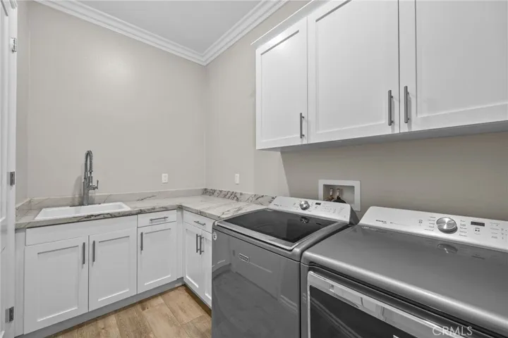 Indoor laundry room with sink and storage and beautiful quartzite countertops.
