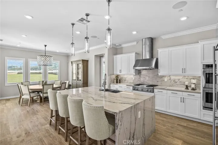 Oversized kitchen island with stunning quartzite countertops with waterfall edges, and versatile breakfast bar.