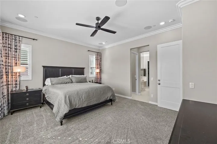 Spacious en-suite primary bedroom freshly painted with custom drapery