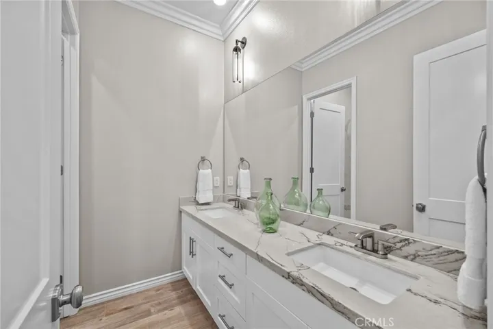 Upgraded bathroom with quartzite countertops, double sinks, and custom cabinetry