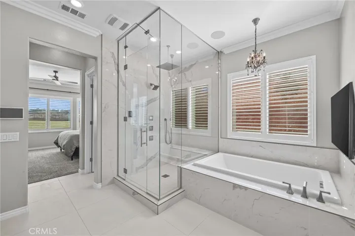 Spa like primary bathroom with Bedrosians quartz flooring, steam shower, and soaking tub.