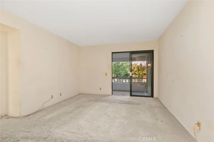 PRIMARY BEDROOM OPENS TO A LARGE COVERED PATIO WITH VIEWS OF GOLD COURSE AND TREES.