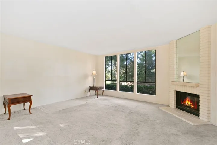 SPACIOUS LIVING ROOM WITH A COZY FIREPLACE.