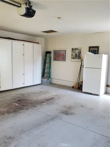 Garage with lots of storage cabinets and extra refrigerator