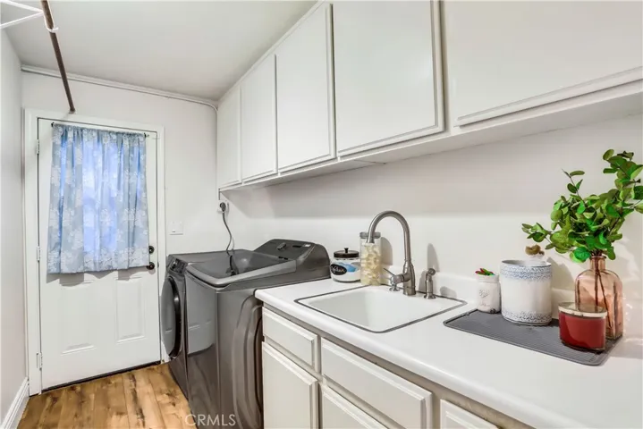 Full Sized Laundry Room with Sink and Loads of Cabinet Space.