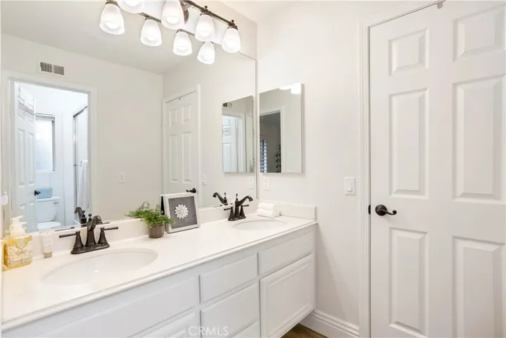 Jack N Jill Bathroom with dual sinks and shower over tub.