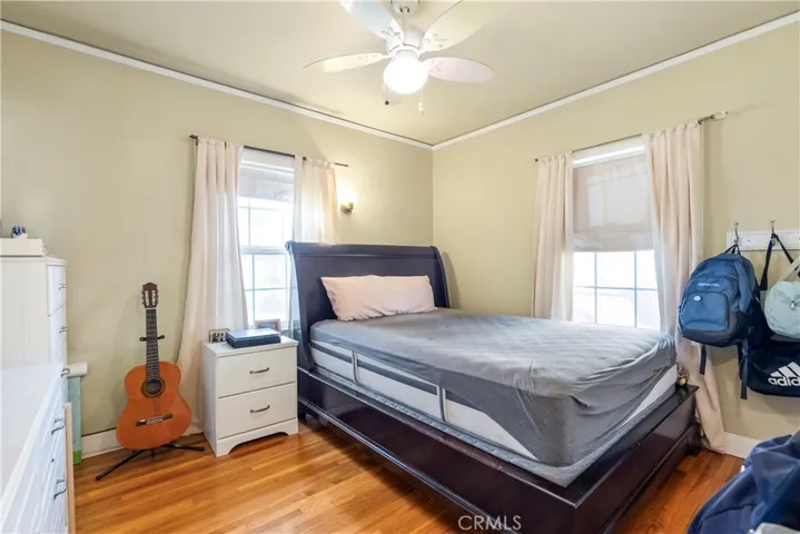 Bedroom #2 with ceiling fan and hardwood floors.
