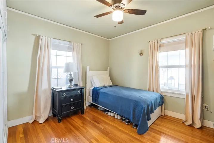 Bedroom #1 with ceiling fan and hardwood floors.