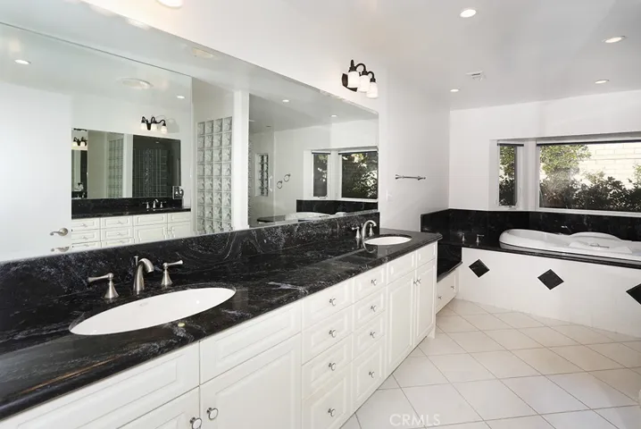 Primary bathroom - double sink vanity, separate tub overlooking garden area