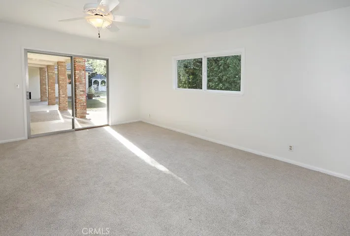 Alternate view of primary bedroom looking to back patio