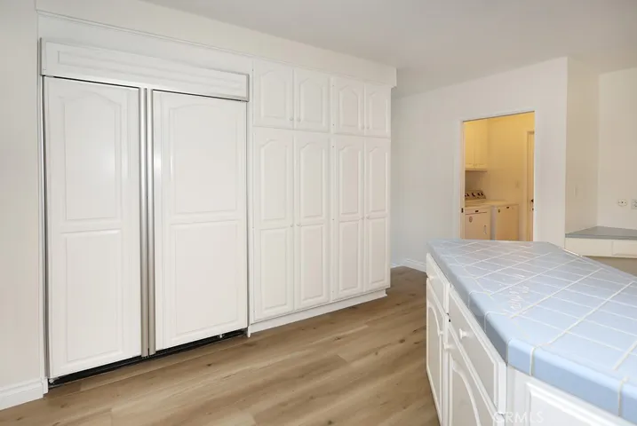 Built-in refrigerator and pantry/storage; door toward the back leads to inside laundry room and 1/2 bath