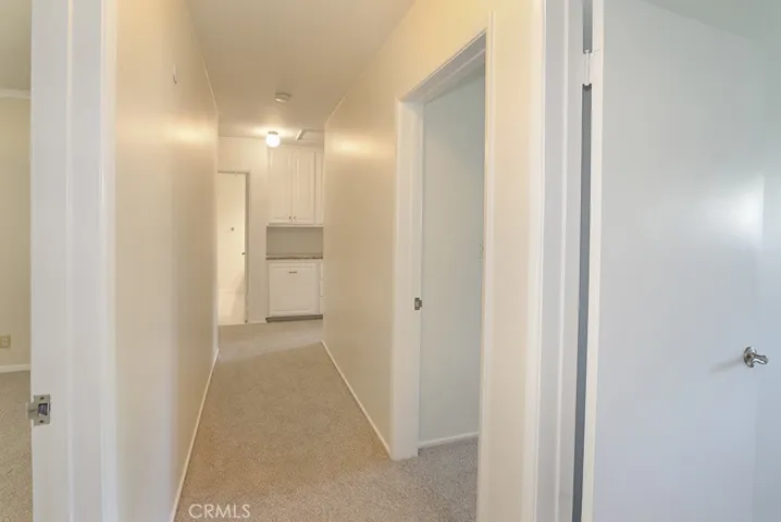 Hallway leading to bedroom wing from front entrance - door helps to separate entertaining space and bedrooms
