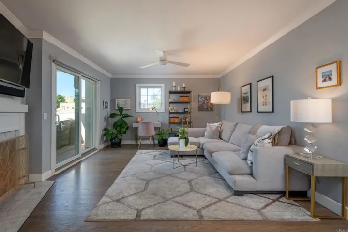 A lovely family room w/cozy fireplace, crown moulding & real wood floors opens to an expansive deck