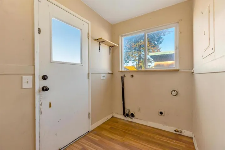 Laundry room off of the kitchen with a door to the backyard