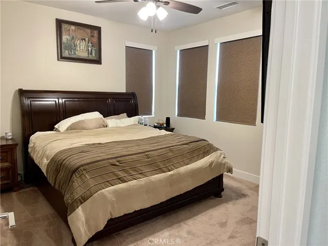 Comfortable principal bedroom with custom blinds