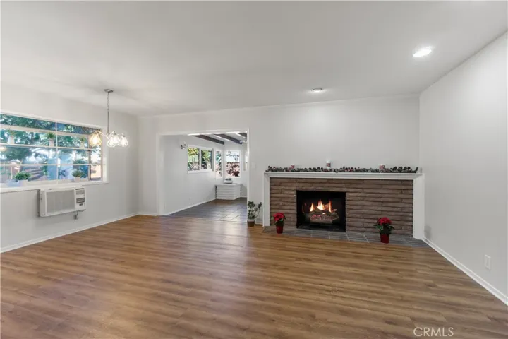 Entry leads directly into the living/dining room area which has vinyl planks, recessed lighting and fireplace which creates an ambiance of warmth and comfort. Bay window views the west side yard and orange tree. Hanging light fixture is new. Wall a/c unit helps keep this area cool. Home also has an attic fan which helps.
