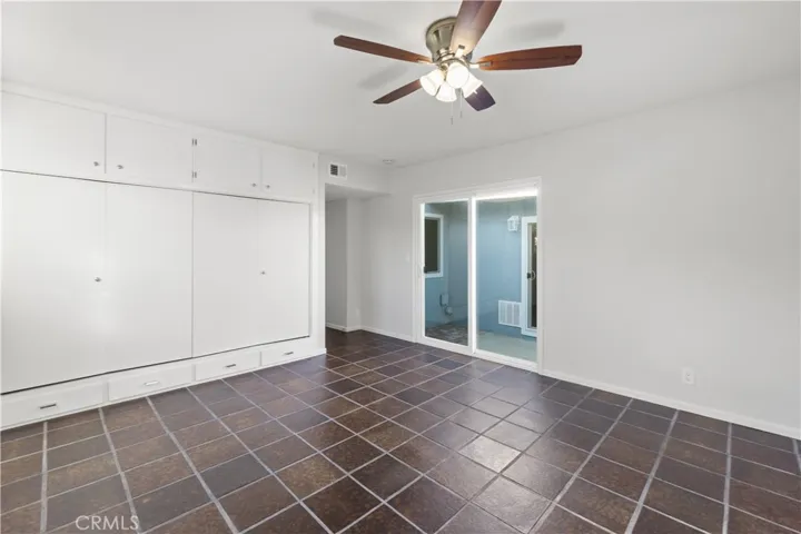 Master bedroom has an oversized closet with cabinet space above. Closet/cabinets were refinished with new knobs/handles/hinges. Sliding glass door is double pane and new, which leads to the patio area.