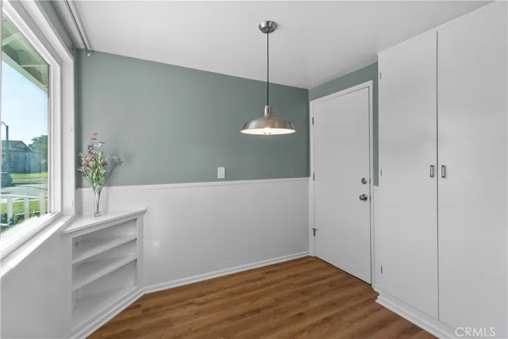 Breakfast nook space is just off the kitchen. Cabinets provide extra room for storage. Door leads into the laundry room area/garage. New vinyl planks were installed. Light fixture is new.