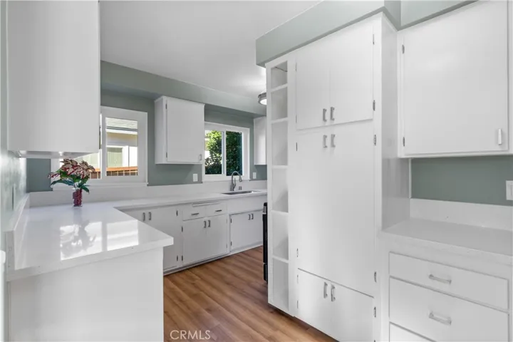 View from the entryway. All cabinets have been refinished with new handles and hinges. There's a lot of cabinet space. Kitchen has new double pane windows.