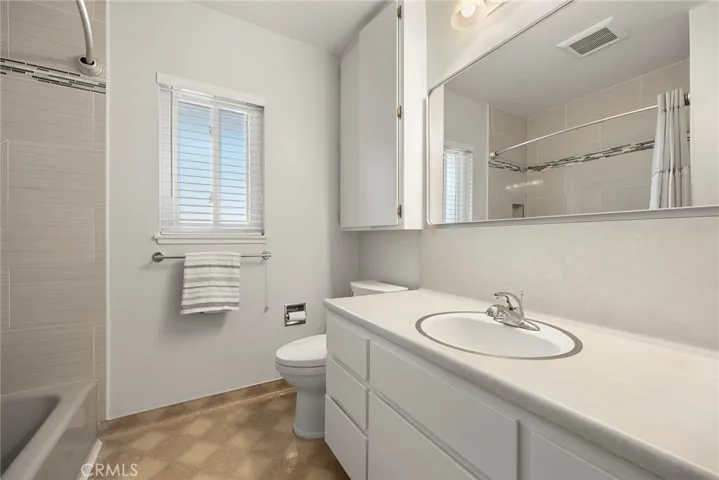 Bathroom 2 with newly painted cabinets, large upper linen area and new framed mirror