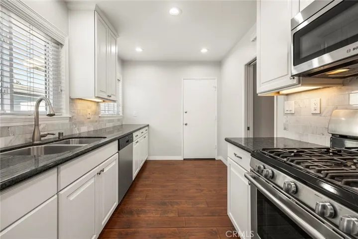 Direct garage/laundry access to kitchen with stainless appliances, including Bosch dishwasher, dual stainless sinks and under cabinet lighting