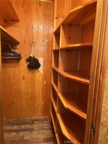 WOW, look at all this space in the walk-in closet! Lots of shelves for storage and a place to hang your clothes.