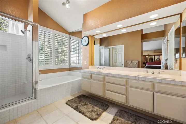 Dual sinks, light and bright, with bonus vaulted ceilings in this primary bathroom!