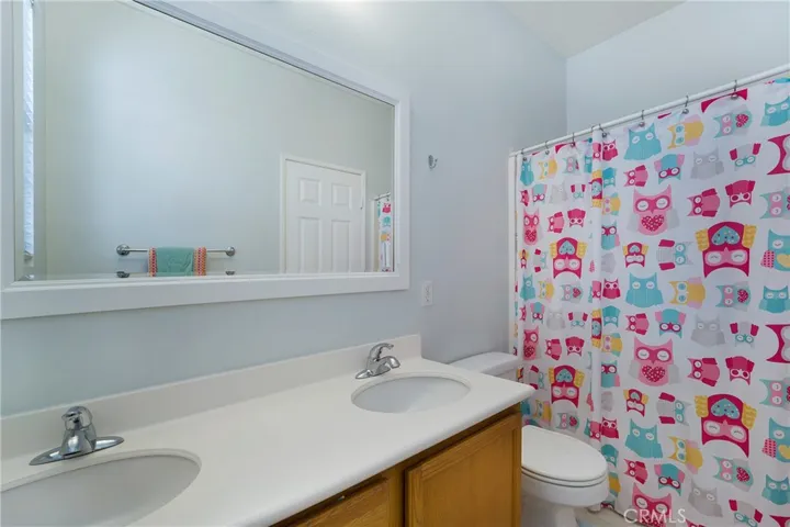 Secondary upstairs bath provides dual vanities, tub and shower.